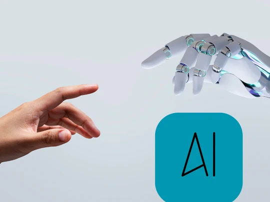 Ręka ludzka i ręka robota sięgające do siebie, podpis "AI"